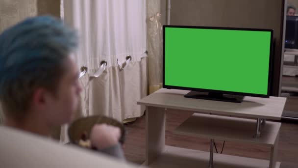 Uomo guardando TV schermo verde Mock Up 4K — Video Stock