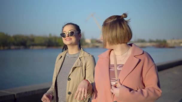 Mujeres jóvenes caminando en muelle, hablando y riendo — Vídeo de stock