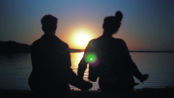 Pareja de siluetas enamorada al atardecer en la playa. Acogedora y romántica noche . — Vídeo de stock