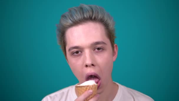 Jeune homme heureux avec des cheveux de couleur manger de la crème glacée en gaufre tasse portrait — Video
