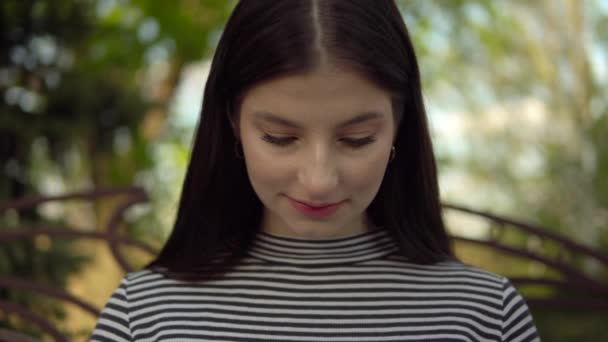 Молодая женщина крупным планом портрет смотрит на ноутбук, работает на открытом воздухе в парке — стоковое видео