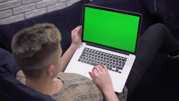 Computer portatile modello di schermo verde, l'uomo che utilizza il computer portatile, rilassarsi sul divano a casa — Video Stock