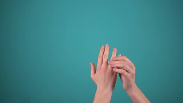 Женщина надеть обручальное кольцо изолированы на синем фоне — стоковое видео