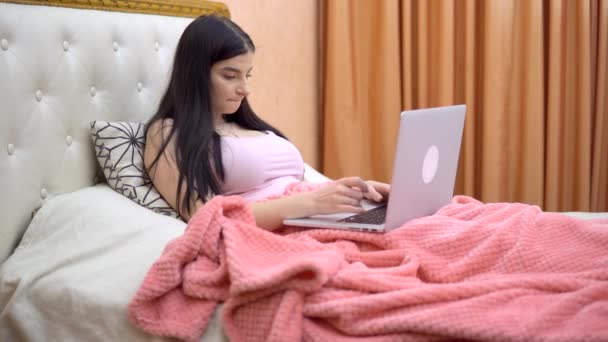 Freelancer mujer trabajando con el ordenador portátil en la cama, acogedor hogar atmosthere, cuarentena — Vídeo de stock