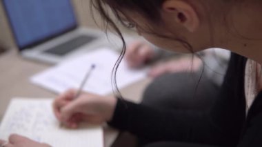 Bilgisayarla çalışan genç çekici kız öğrenciler, online ders çalışıyorlar.