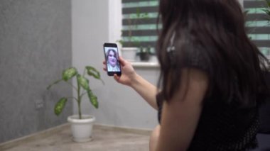 Evde arkadaşlarıyla görüntülü konuşma yapan, akıllı telefon kullanan, mesafeli...