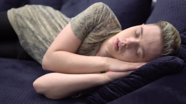 Atraktivní unavený spací mladý muž odpočívající na pohovce v útulném domě — Stock video