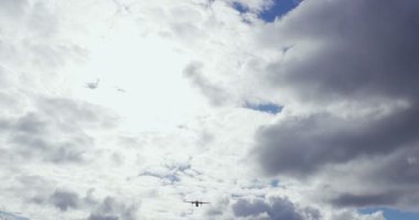Güneşli bir beyaz bulutlar ile dikey Askılı köprü sırasında ticari yolcu uçağı