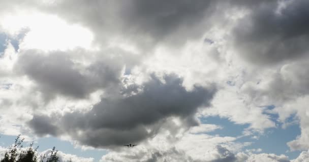 Kommersiella passagerare trafikflygplan under vertikala Overhead viadukt en solig dag med vita moln — Stockvideo