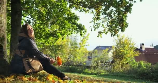 Mooie jongedame ontspannen in herfst park. — Stockvideo