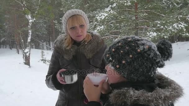Familia feliz tomando té caliente al aire libre en invierno 96fps — Vídeo de stock