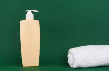 Yeşil arka planda bir şişe şampuan ya da saç kremi