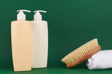 Yeşil arka planda bir şişe şampuan ya da saç kremi