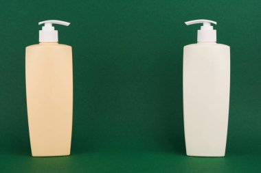 Yeşil arka planda bir şişe şampuan ya da saç kremi