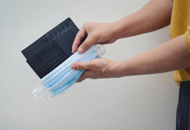 Yüz maskeleriyle dolu bir cüzdan taşıyan kişi