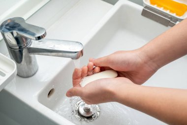 Bakteri ve virüslerden korunmak için ellerini sabunla yıkıyorsun.