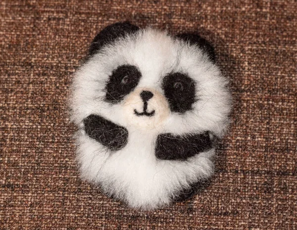 Bir panda broşu, el yapımı, doğal yün ve sahte kürkten yapılmış..