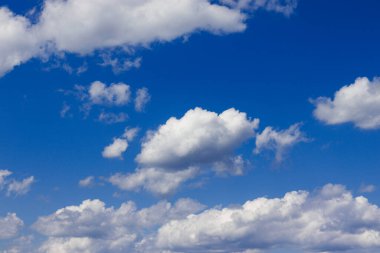 Mavi gökyüzünde kar beyazı bulutlar. Fotoğraf, Rusya 'nın Chelyabinsk bölgesindeki Uvilda Gölü üzerinde güneşli bir günde çekildi..