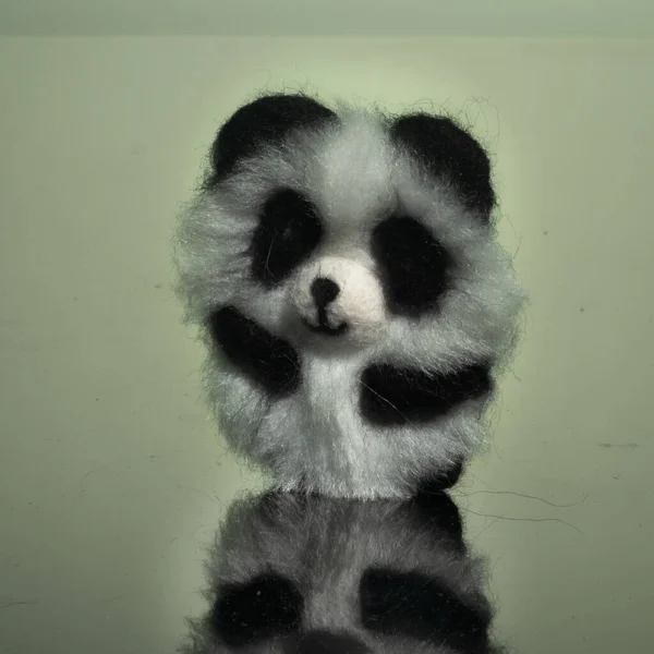 Bir panda broşu, el yapımı, doğal yün ve sahte kürkten yapılmış..