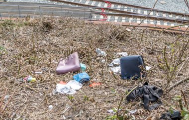 Aarhus, Danimarka - 24 Mart 2020 Aarhus 'taki bir yamaçtan atılan çalıntı çantalar. Çantaların içeriği etrafa saçılmış