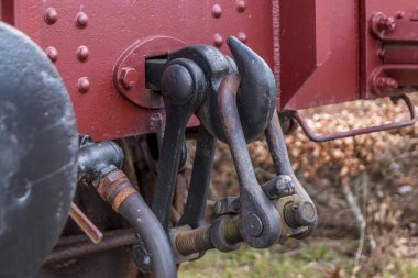 Raylı eski tren vagonu, kırmızı ahşap tren vagonu. Yük vagonlarını bağlamak için eski tarz kanca bağlantıları ve tamponlar.
