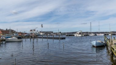 Mariager, Danimarka - 29 Mart 2020: Danimarka 'da deniz kıyısındaki evlere manzaralı bir yat sahnesi