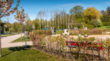 Randers, Danimarka - 09 Maj 2020: The Doctor Park in Randers. İnsanlar doğada oturup kahve içiyorlar. Parkta piknik. Çocuklar oyun alanında oynarlar. yeşil renkler ve mavi gökyüzü