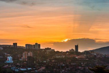 Kigali şehir merkezi gün batımında renkli bulutların altında ufuk çizgisi ve çevre bölgeler. Ruanda
