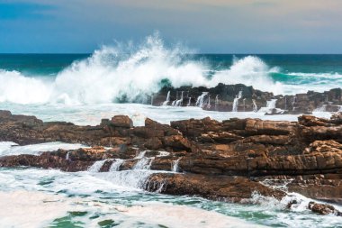Dalgalar fırtınalı kıyılara çarpıyor Storms River Mouth, Tsitsikamma Ulusal Parkı, Güney Afrika