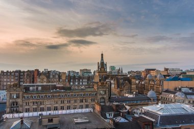 Gün batımında İskoçya 'daki Glasgow şehir merkezinin binalarını ve mimarisini gören geniş bir çatı manzarası.
