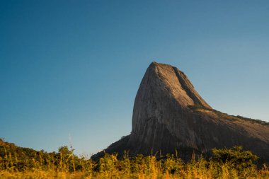 Bulutsuz mavi bir gökyüzünün altında, dik bir kaya tepesinin sivri tepesi. Mozambik, Afrika