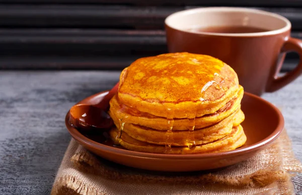 Pumpkin pancakes on plate with honey — Stock Photo, Image