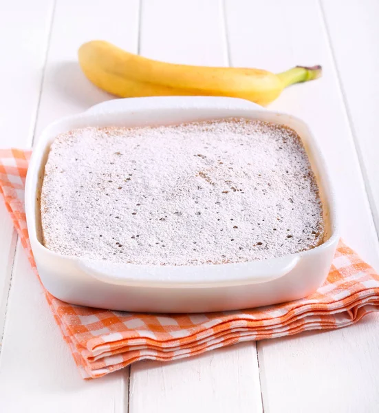 Banana pudding in a tin  with icing sugar — Stock Photo, Image