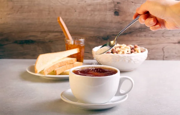 Añadir azúcar en el té en una taza , —  Fotos de Stock