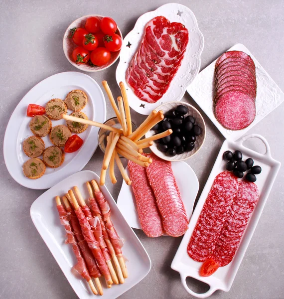Mix produktów mięsnych oraz przekąski serwowane na stole — Zdjęcie stockowe