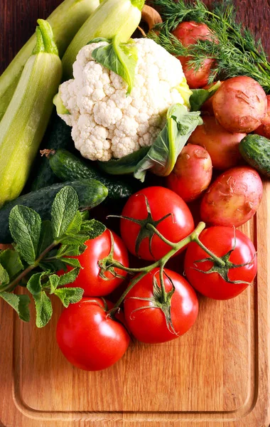 Verduras frescas crudas sobre tabla de madera — Foto de Stock