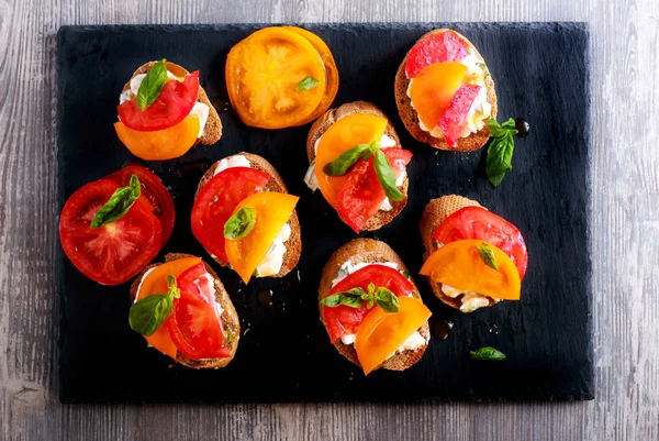 Queso y tomate de albahaca rematado bruschetta — Foto de Stock