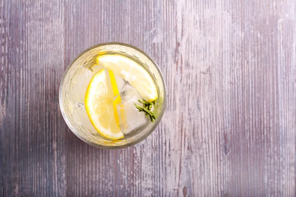 Soğuk limon ve biberiye içinde içerken — Stok fotoğraf
