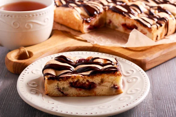 Sponge fruit cake with chocolate drizzle — Stock Photo, Image