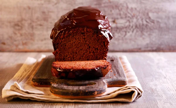 Chocolate cake with chocolate icing on board — Stock Photo, Image