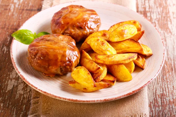 Beefsteaks wrapped in bacon and roast potato — Stock Photo, Image