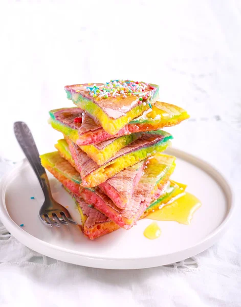 Rainbow pancake slices with honey — Stock Photo, Image