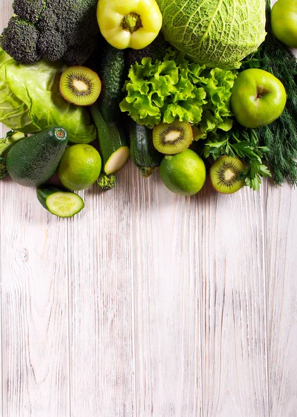 緑の野菜と木製の背景の上の果実 — ストック写真