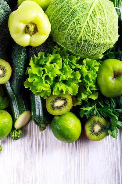 緑の野菜と木製の背景の上の果実 — ストック写真