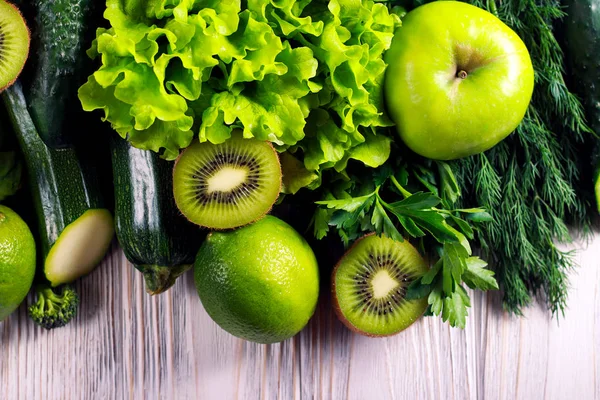 Verduras verdes e frutas sobre fundo de madeira — Fotografia de Stock