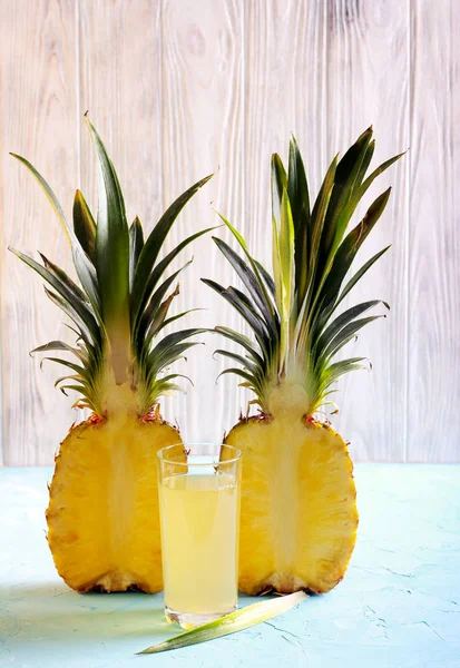 Pineapple half and pineapple juice in a glass