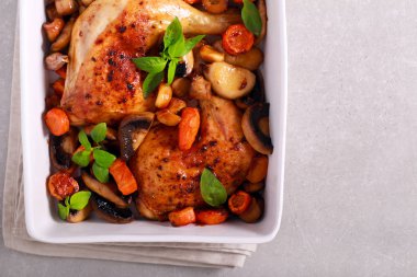 Tavuk bacağı mantar ve havuçla pişirilir. 