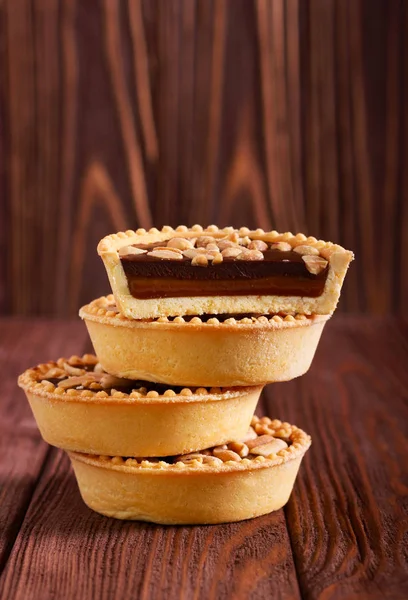 Caramel, peanut and chocolate mini tarts — Stock Photo, Image