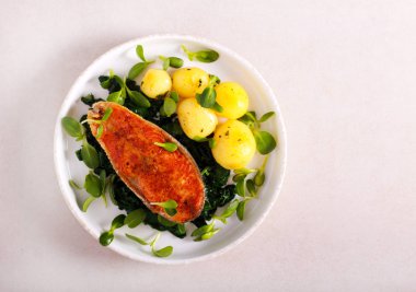 Kızarmış somon, ıspanak ve patates. 