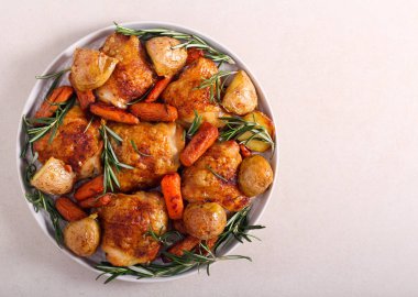 Kızarmış tavuk budu, patates, havuç ve biberiye. 